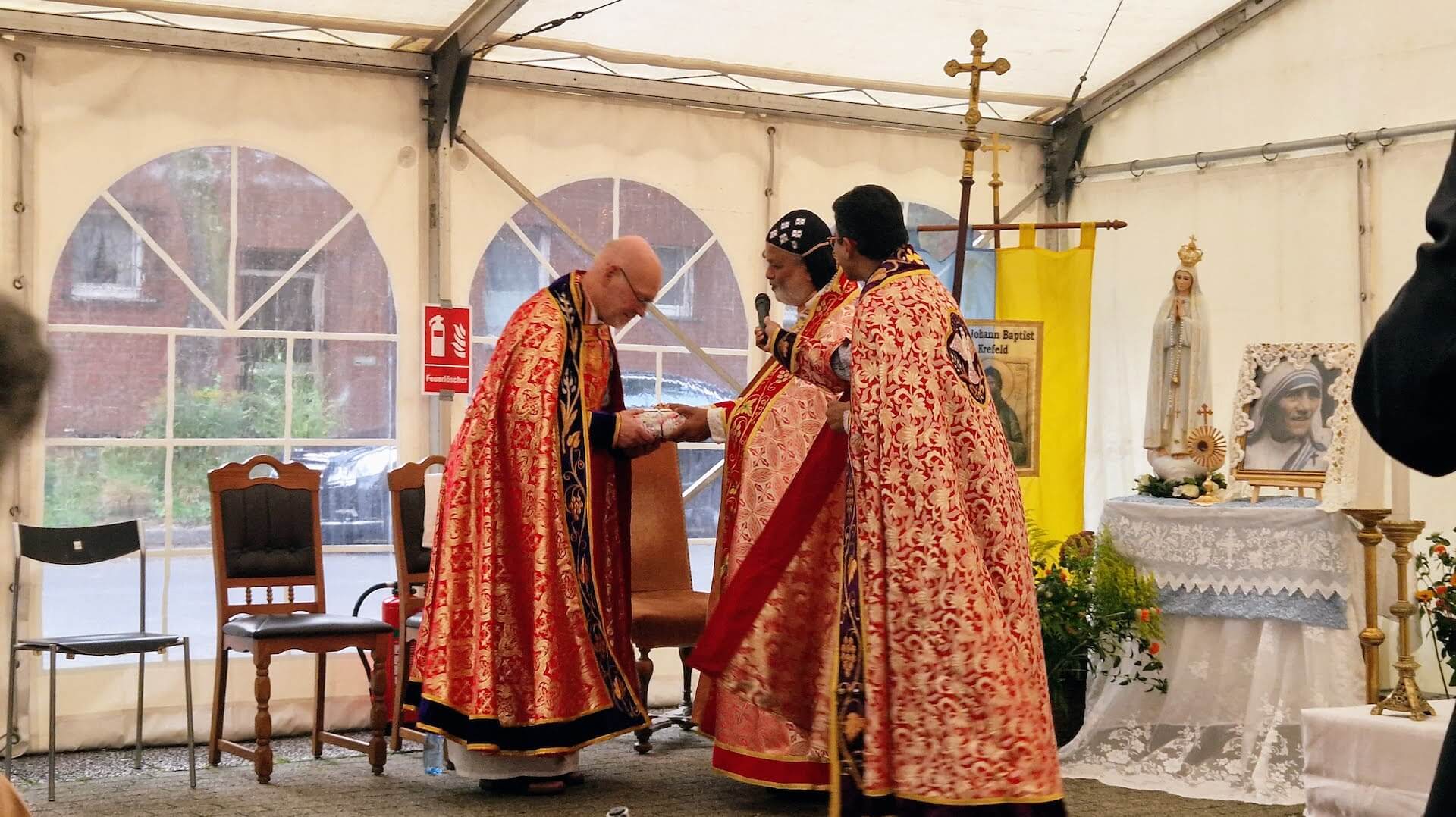 Bischof Joshua  überreicht Pfr. Schwarzmüller ein Geschenk zu dessen silbernem Priesterjubiläum